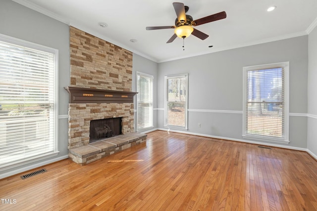 unfurnished living room featuring ceiling fan, visible vents, wood-type flooring, and ornamental molding