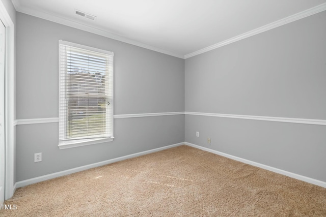 unfurnished room featuring carpet flooring, baseboards, visible vents, and ornamental molding