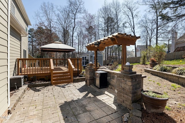 view of patio / terrace featuring an outbuilding, a fenced backyard, a gazebo, a deck, and a storage shed