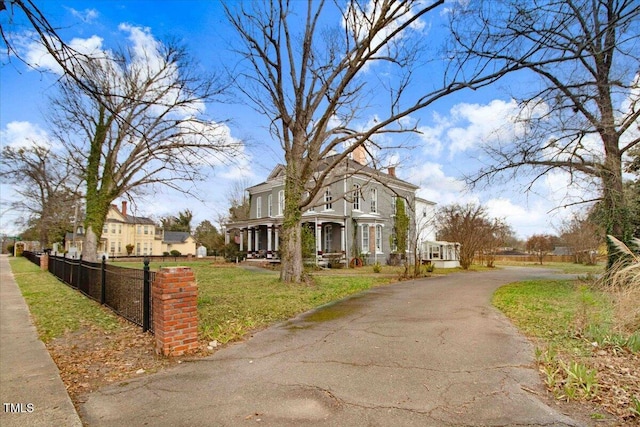 view of front of property featuring driveway, a front yard, and fence