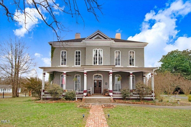 italianate-style house featuring a front yard, covered porch, and a chimney