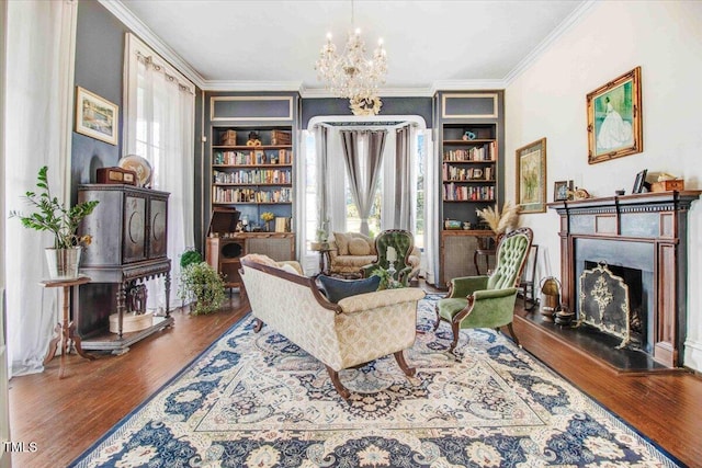 sitting room featuring plenty of natural light, a fireplace with raised hearth, an inviting chandelier, and ornamental molding