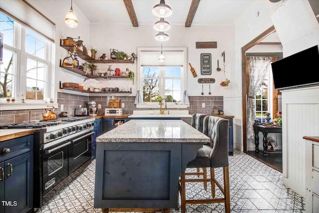 kitchen featuring blue cabinets, beamed ceiling, double oven range, a kitchen island, and backsplash