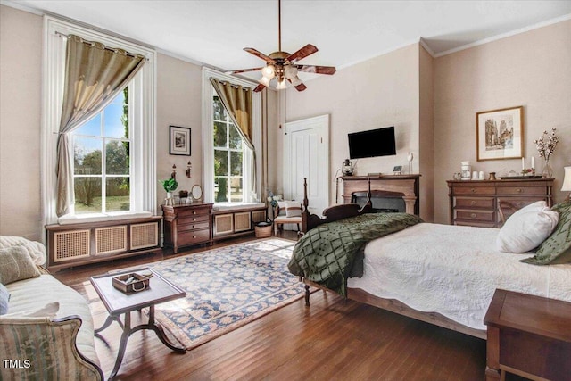 bedroom featuring ornamental molding, radiator, and wood finished floors