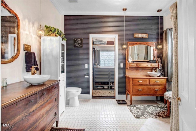 bathroom with toilet, vanity, and ornamental molding