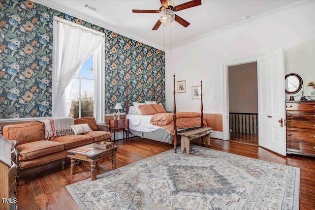 bedroom featuring ceiling fan, visible vents, hardwood / wood-style floors, and crown molding