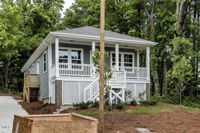 view of front of home featuring covered porch and stairs