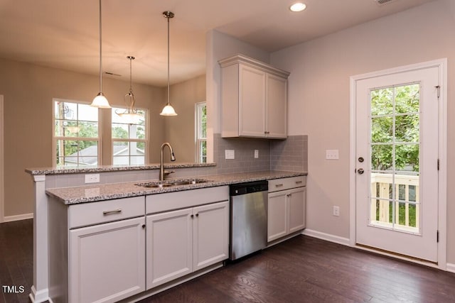 kitchen with decorative backsplash, a peninsula, stainless steel dishwasher, dark wood-style floors, and a sink