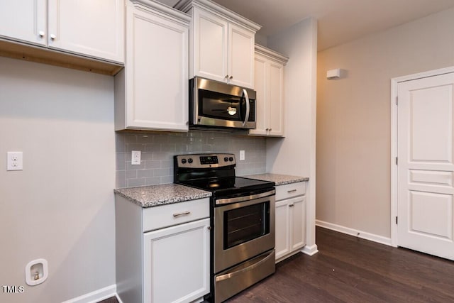 kitchen with tasteful backsplash, stainless steel appliances, dark wood-type flooring, and light stone countertops