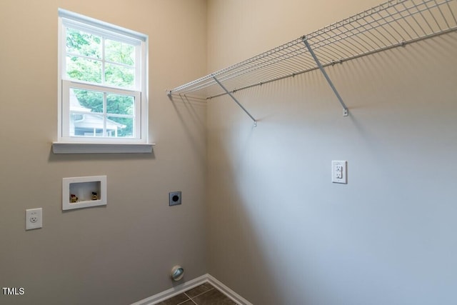 laundry area with dark tile patterned flooring, baseboards, hookup for an electric dryer, hookup for a washing machine, and laundry area