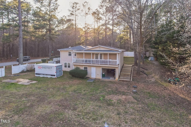 back of house featuring stairs, a yard, and a wooden deck