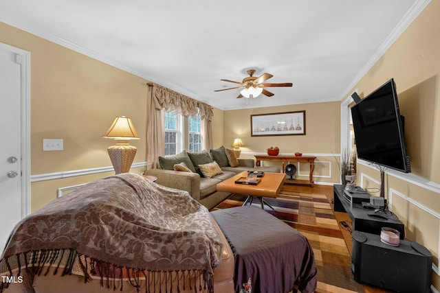 living room featuring a wainscoted wall, crown molding, and ceiling fan