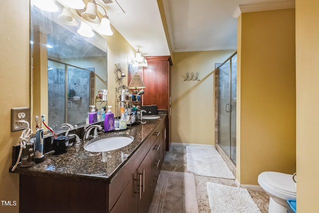 full bath with double vanity, a stall shower, crown molding, and a sink