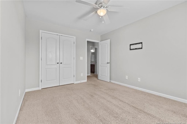 unfurnished bedroom featuring a closet, baseboards, carpet, and a ceiling fan