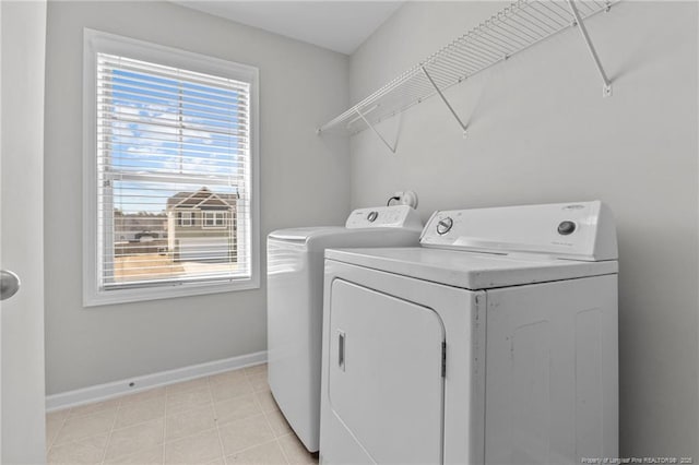 laundry room with laundry area, washing machine and dryer, and baseboards