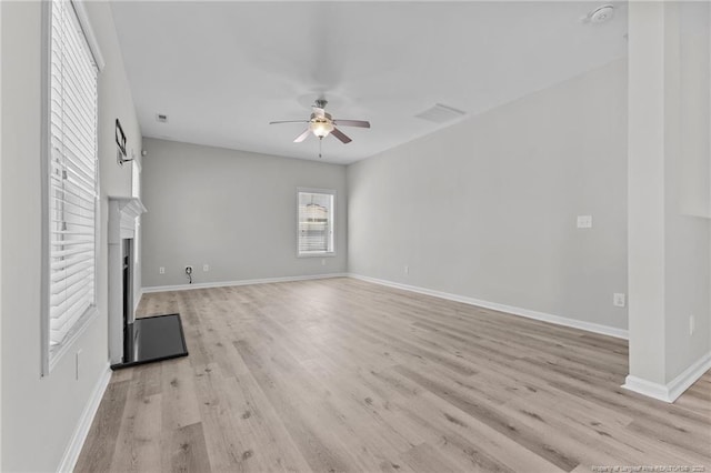 unfurnished living room featuring visible vents, baseboards, a fireplace, light wood-style floors, and a ceiling fan