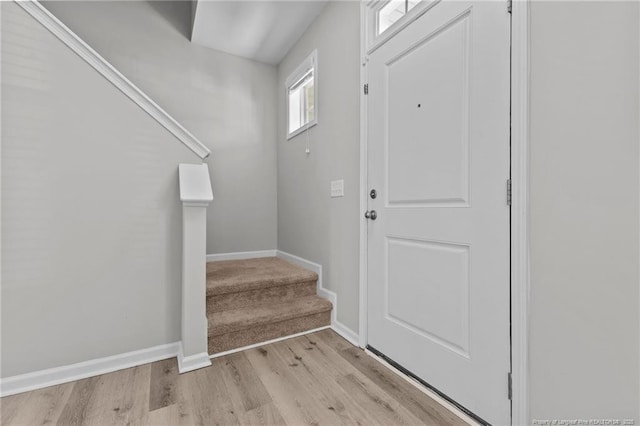 entrance foyer with baseboards, stairs, and light wood finished floors