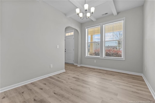 interior space featuring visible vents, baseboards, light wood-style floors, arched walkways, and a notable chandelier