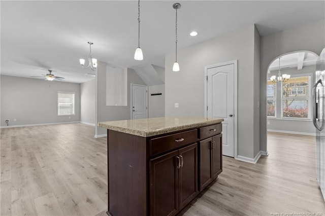 kitchen with light wood finished floors, dark brown cabinets, baseboards, decorative light fixtures, and ceiling fan with notable chandelier