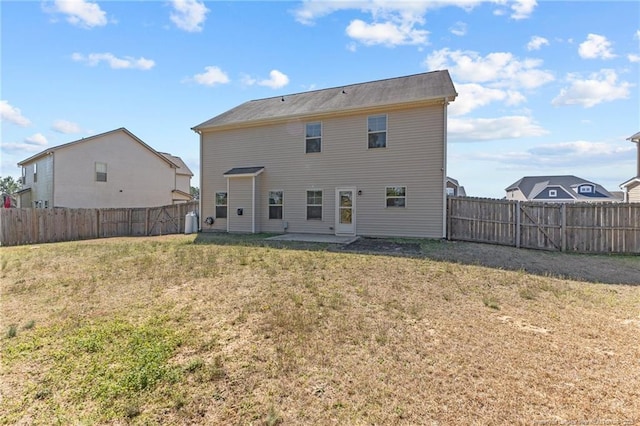 back of property featuring a lawn, a patio, and a fenced backyard