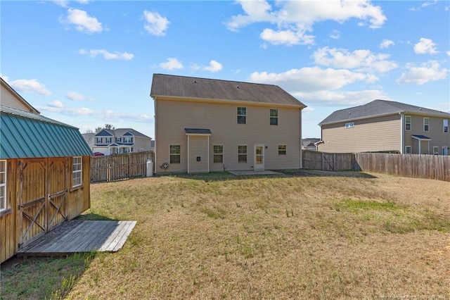 back of property featuring an outbuilding, a lawn, and a fenced backyard