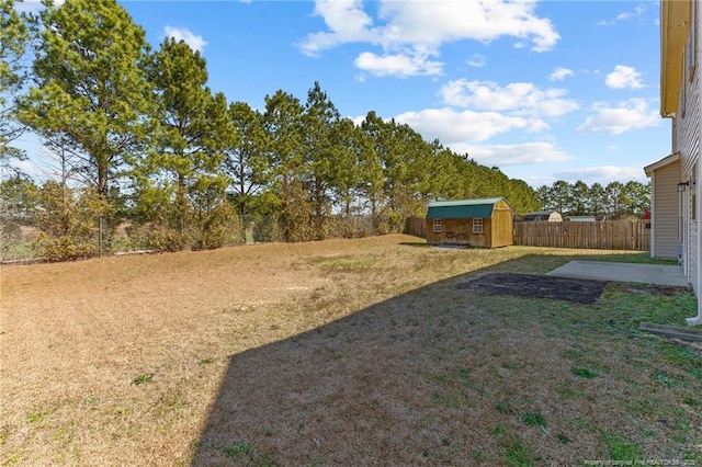 view of yard with a patio area, a storage unit, an outdoor structure, and fence