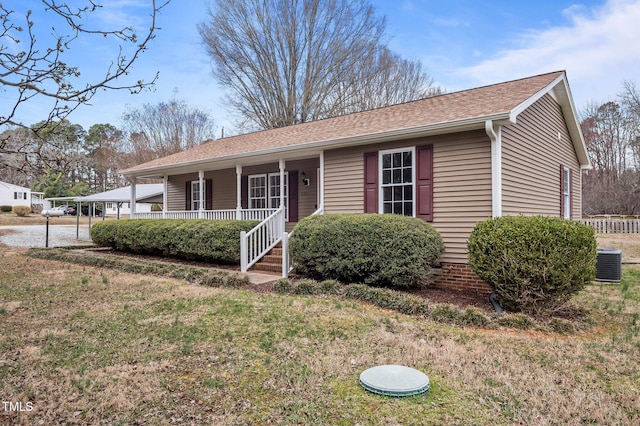 ranch-style home with cooling unit, a porch, and a front lawn