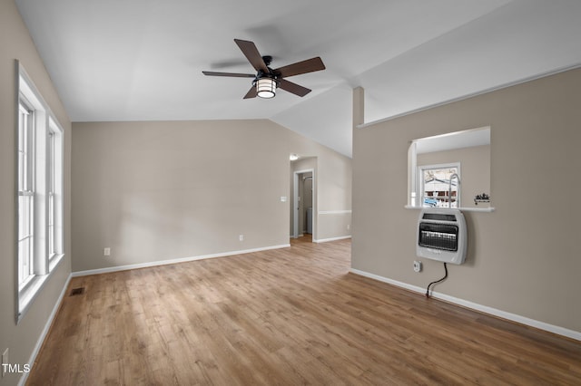 unfurnished living room featuring heating unit, wood finished floors, visible vents, lofted ceiling, and ceiling fan