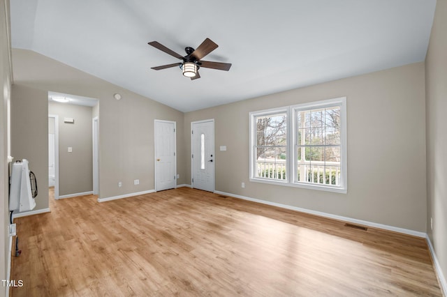 unfurnished living room with lofted ceiling, light wood-style flooring, baseboards, and ceiling fan