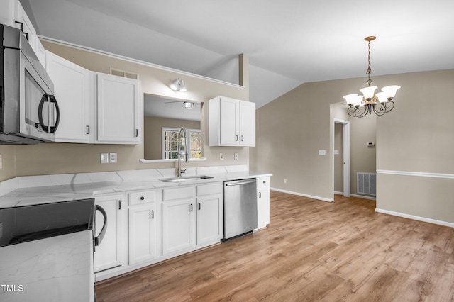 kitchen with a sink, visible vents, a chandelier, and stainless steel appliances