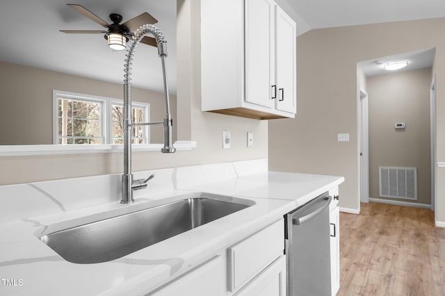 kitchen with visible vents, white cabinets, and stainless steel dishwasher