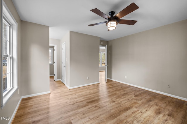 unfurnished room with light wood-style flooring, baseboards, and a ceiling fan