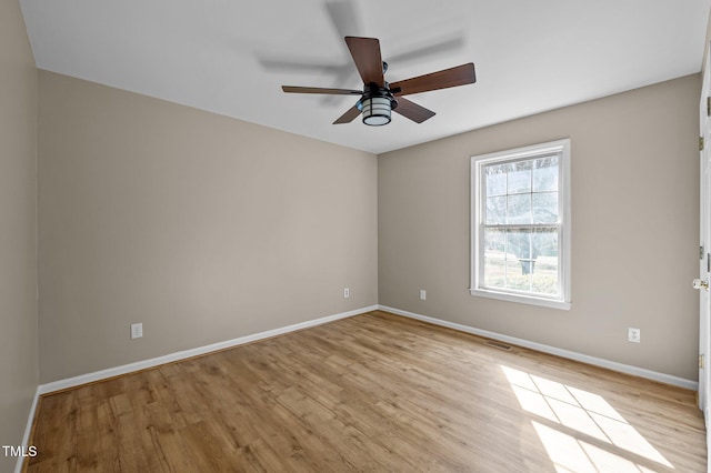 empty room with baseboards, visible vents, a ceiling fan, and light wood-style floors