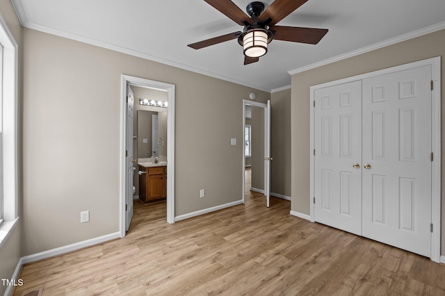 unfurnished bedroom featuring a closet, baseboards, light wood-style floors, and ornamental molding