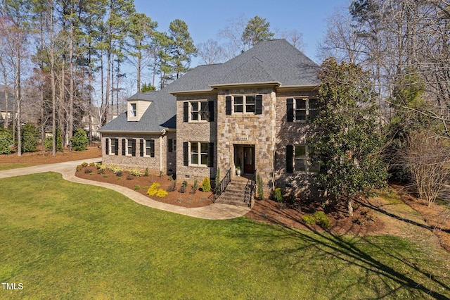 view of front facade with stone siding, a shingled roof, and a front lawn