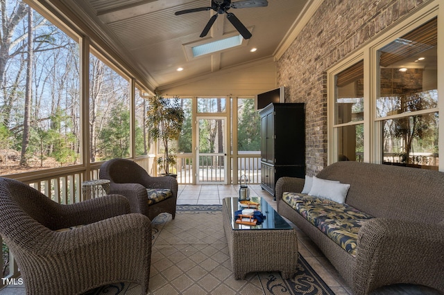 sunroom / solarium with vaulted ceiling with skylight and a ceiling fan