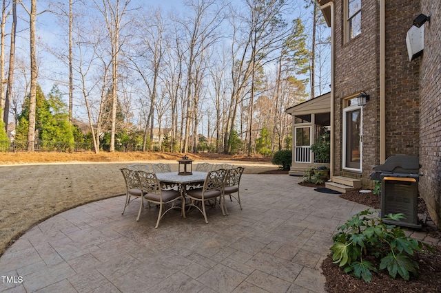 view of patio / terrace with grilling area, fence, entry steps, a sunroom, and outdoor dining space