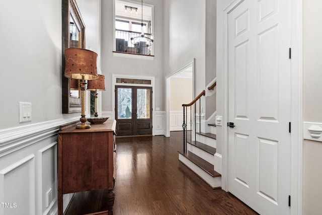 entryway with french doors, plenty of natural light, dark wood-type flooring, and stairs