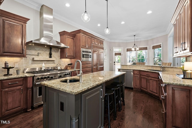 kitchen with a sink, stainless steel appliances, dark wood finished floors, and wall chimney range hood