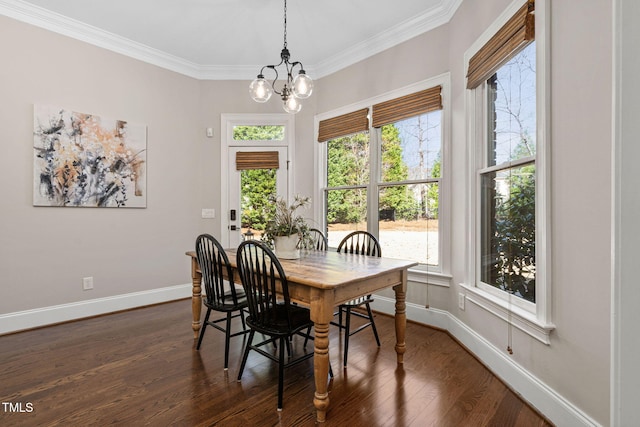 dining area with baseboards, dark wood-type flooring, an inviting chandelier, and ornamental molding