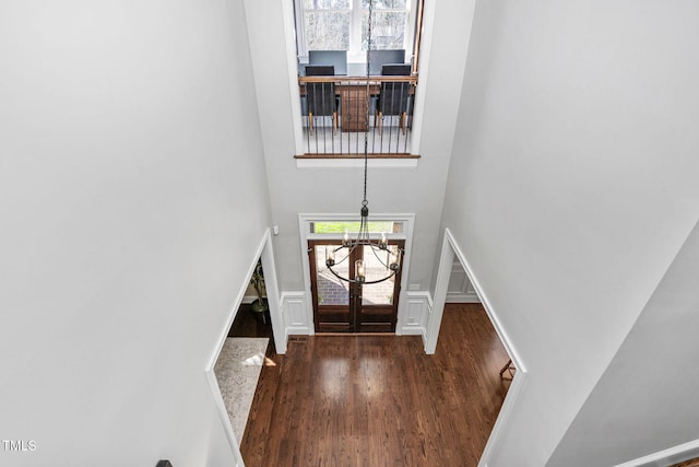 entryway featuring a high ceiling, an inviting chandelier, and wood finished floors