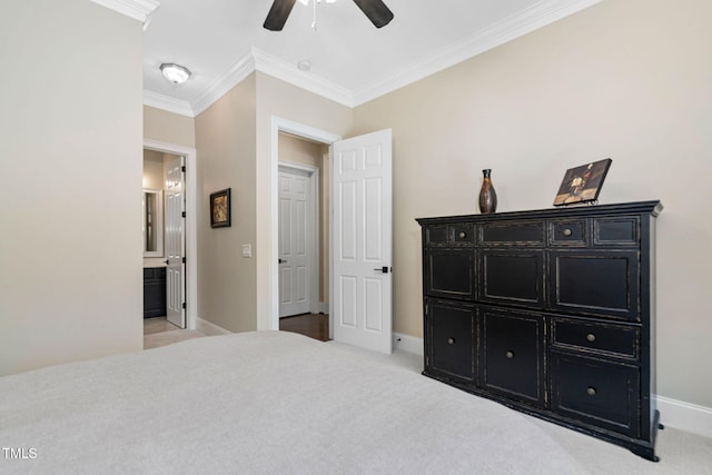 bedroom featuring carpet flooring, ensuite bathroom, crown molding, and baseboards