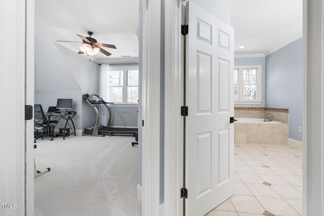 exercise room featuring a ceiling fan, baseboards, ornamental molding, tile patterned flooring, and carpet flooring