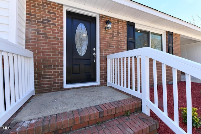 doorway to property featuring brick siding