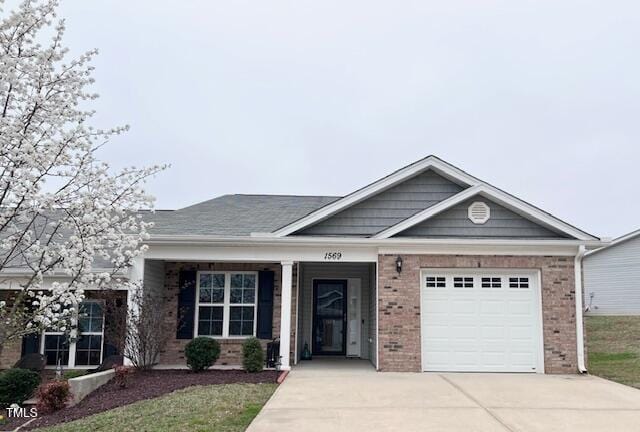 view of front of house featuring a garage, brick siding, and driveway