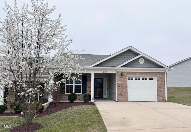 single story home with a garage, brick siding, concrete driveway, and a front yard