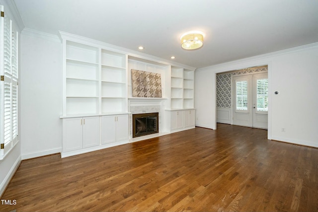 unfurnished living room with crown molding, baseboards, a tiled fireplace, recessed lighting, and wood finished floors