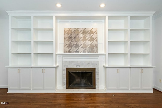 unfurnished living room featuring a fireplace with flush hearth, recessed lighting, and dark wood-type flooring