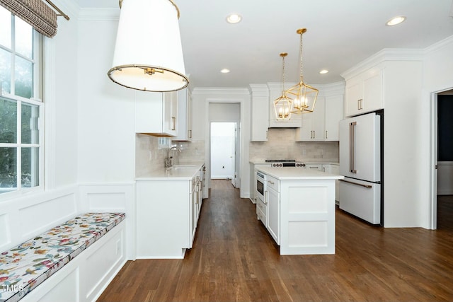 kitchen featuring a sink, crown molding, high end white refrigerator, and light countertops