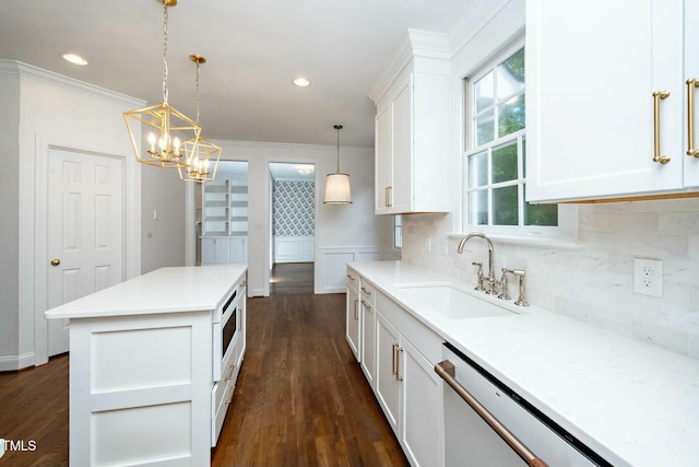 kitchen with dark wood-type flooring, a sink, backsplash, white cabinetry, and dishwashing machine